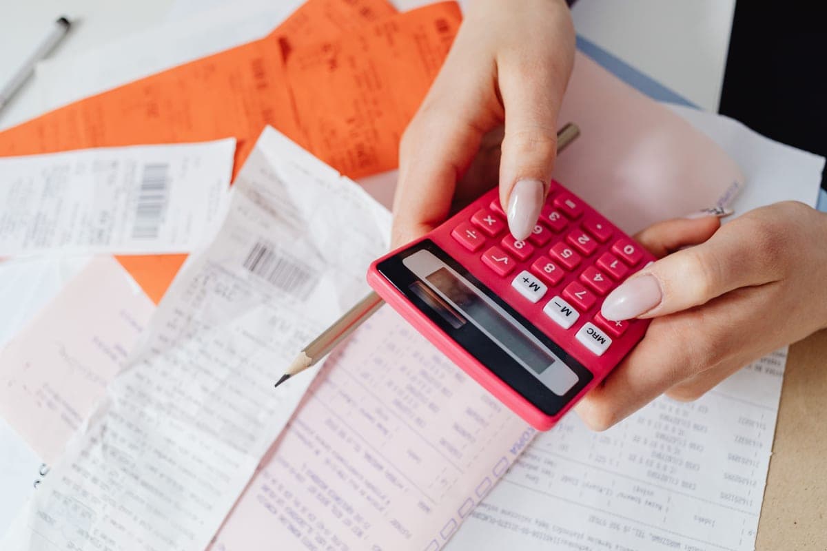 A person working out electricity costs with a calculator and paperwork