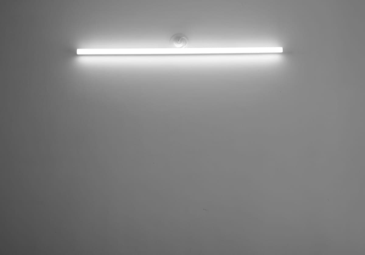 A fluorescent tube light fitting mounted on a white ceiling