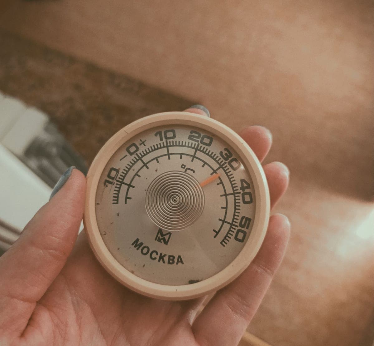 A thermometer measuring temperature in an indoor growing area