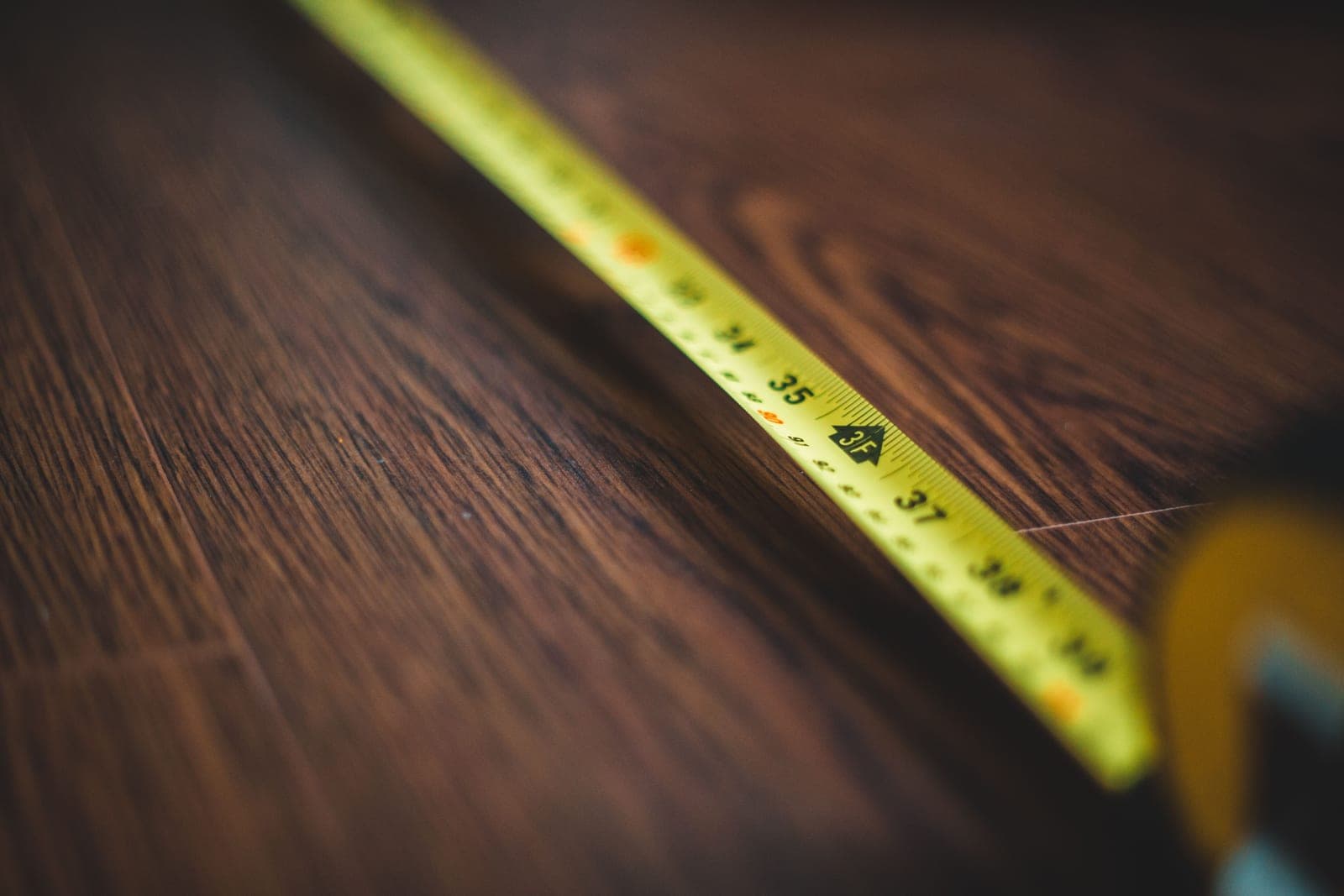 A tape measure laid out on a wooden surface
