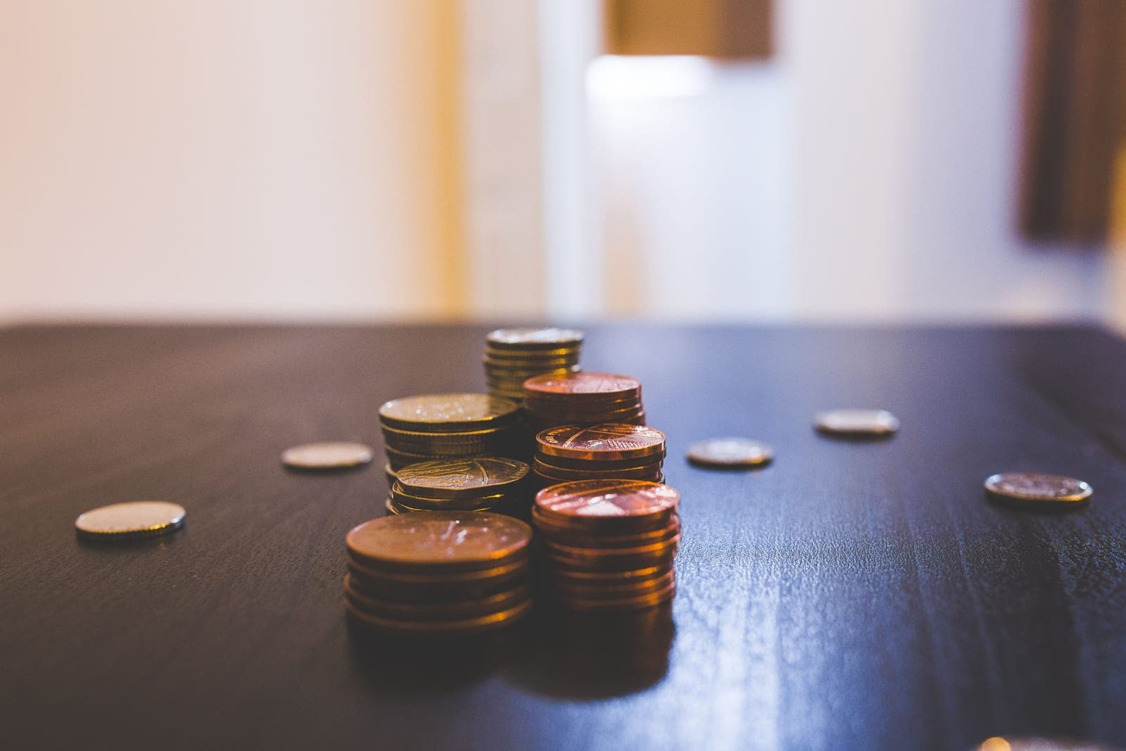 A pile of coins on a wooden table
