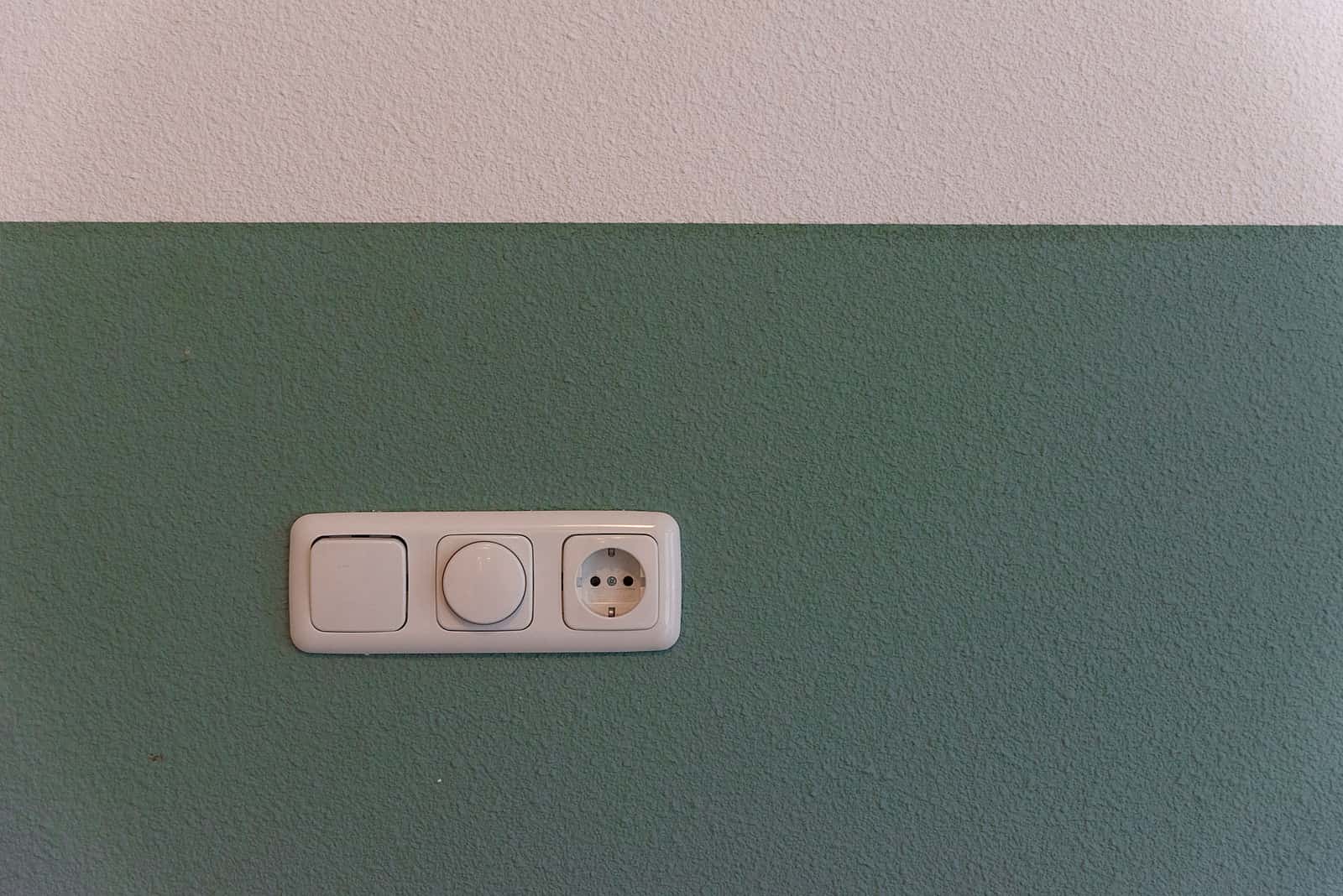 A power outlet and wall switch in an indoor room