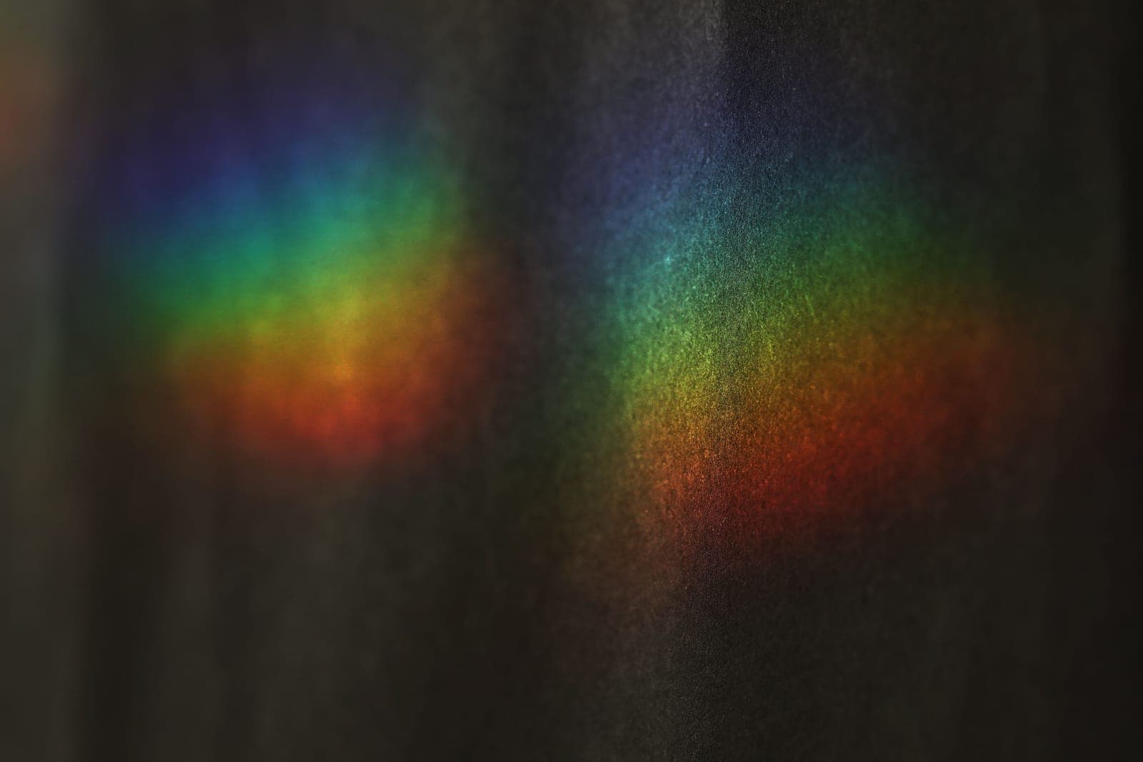 White light split into a band of rainbow colors against a dark background