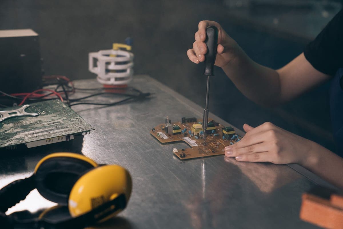 A person inspecting an electrical fixture and its wiring