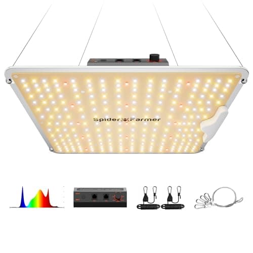 A square white LED grow panel hanging above leafy seedlings indoors